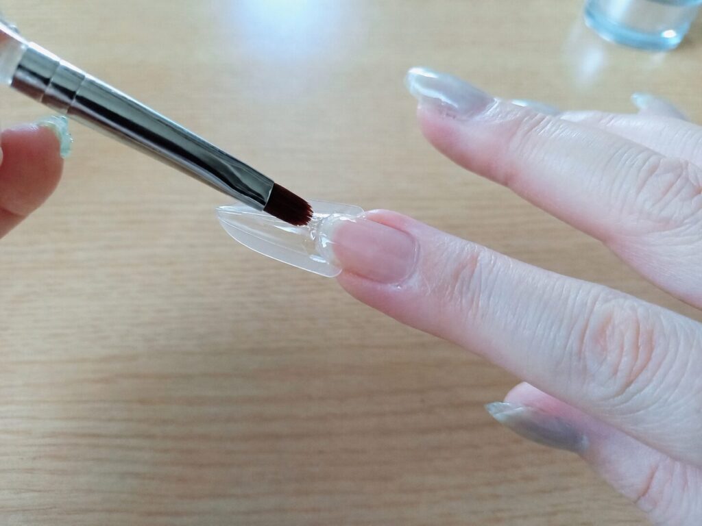 サンドイッチチップの上からジェルを塗る写真